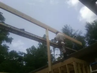 Carpenter setting a ridge beam over a new addition frame — Ice Dam Removal by Roofing Brothers in Lucama