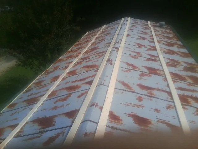 Rusted metal roof panels with new wood purlins before replacement — Storm Damage Roof Repair in Lucama by Roofing Brothers